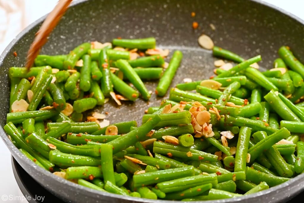 side view of a skillet with green beans and toasted almonds - 7