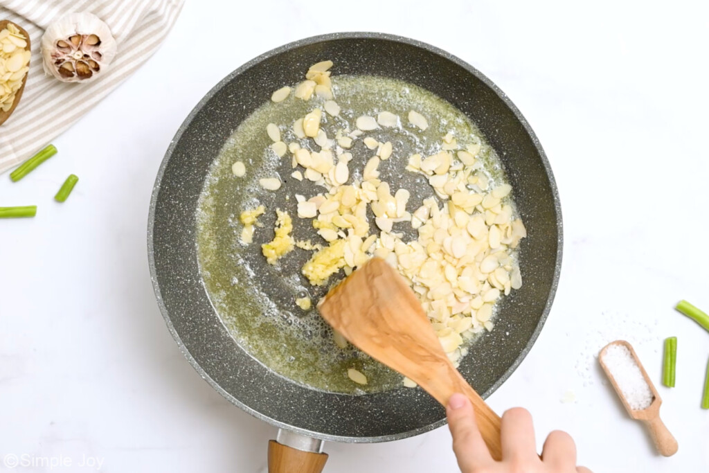 overhead of a skillet toasting almonds and garlic in butter - 6