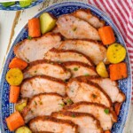 Pinterest graphic for pork roast. Text says "The best pork loin roast simplejoy.com" Image shows overhead of sliced pork roast on a platter with carrots and potatoes