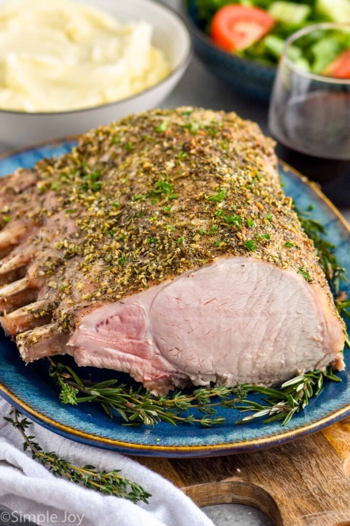 Front facing photo of Roast Pork Loin on a plate with mashed potatoes in the background