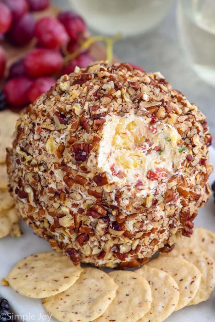 pineapple cheese ball on a serving board surrounded by crackers