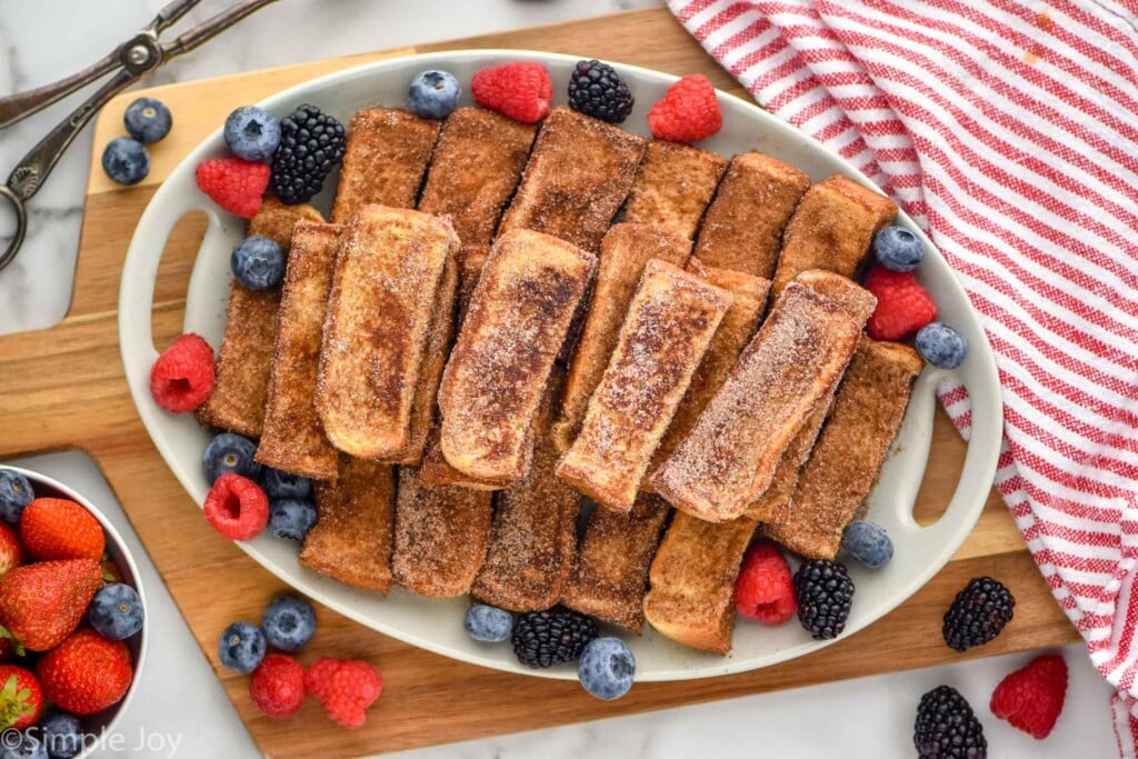 Overhead of platter of french toast sticks garnished with fresh berries