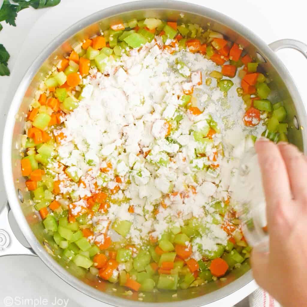 adding flour to a skillet to make a roux for chicken noodle casserole