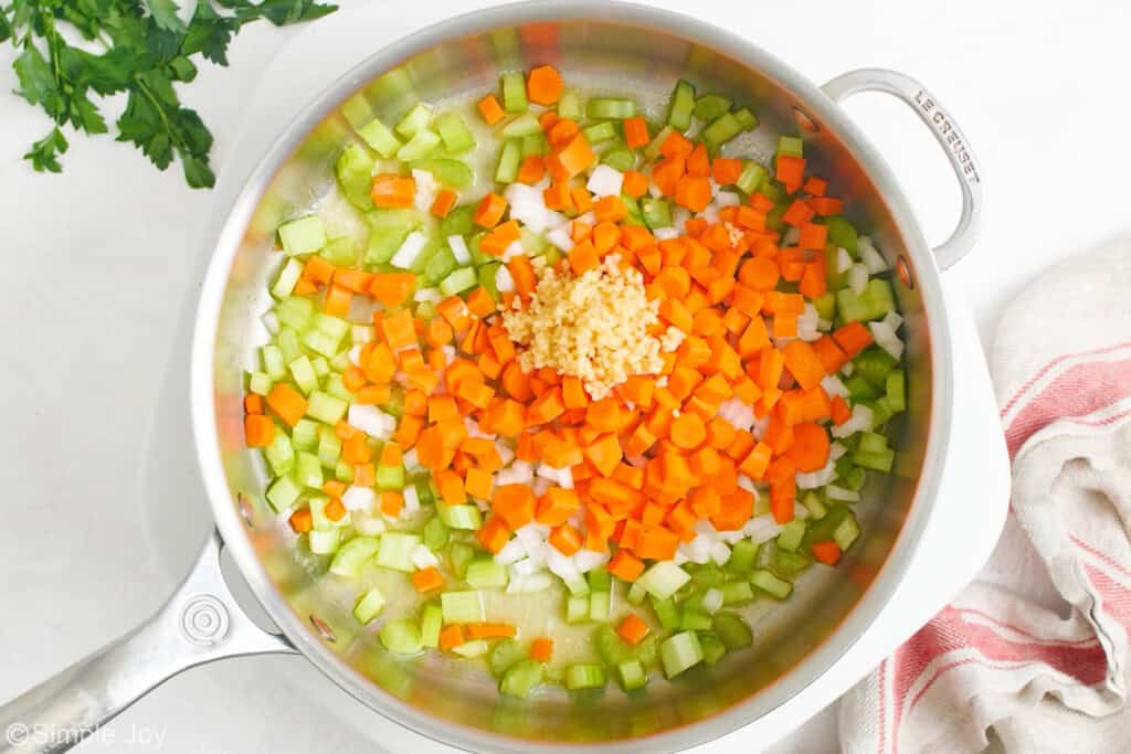 overhead of a skillet with carrots, celery, onions, and garlic