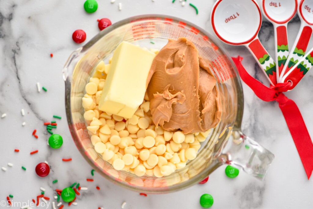 Overhead of glass measuring cup of Christmas puppy chow ingredients for melting