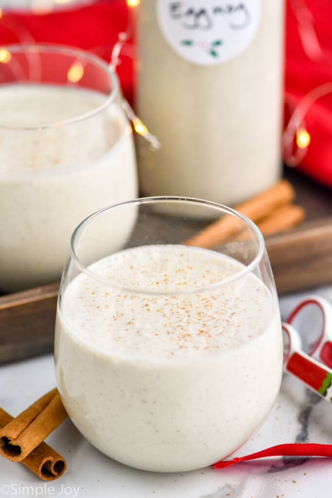overhead shot of eggnog photo in a stemless wine glass with sparkling lights in background