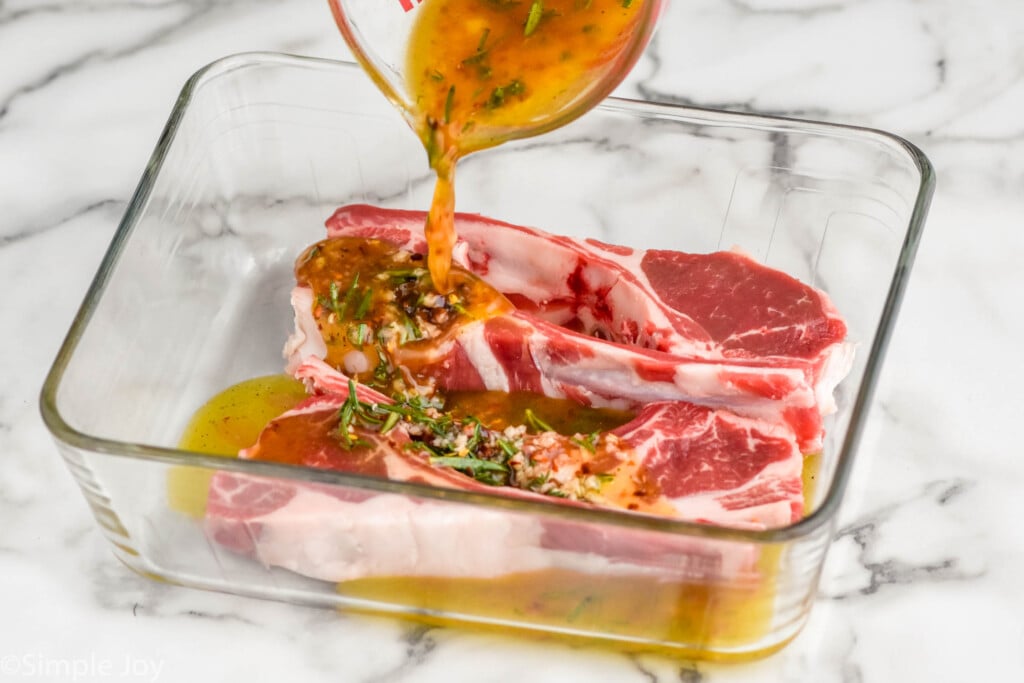 lamb chop marinade pouring over lamb chops in a baking dish