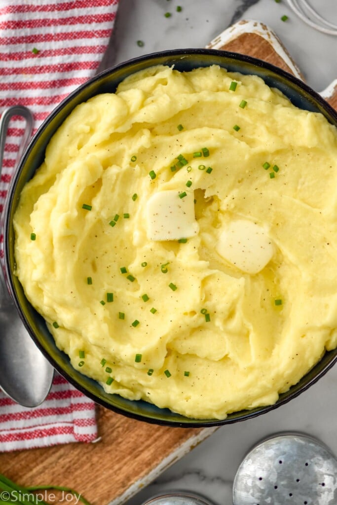 overhead bowl of mashed potatoes topped with butter and chives