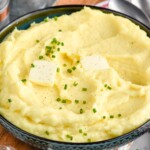 bowl of homemade mashed potatoes topped with butter and chives