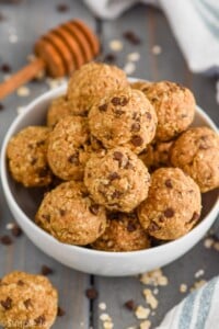 In a white bowl, the Five Ingredient No Bake Energy Bites are shaped into little balls and piled on top of each other.