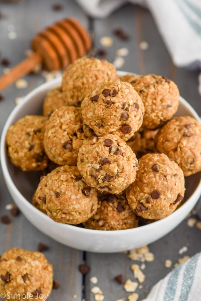 In a white bowl, the Five Ingredient No Bake Energy Bites are shaped into little balls and piled on top of each other. 