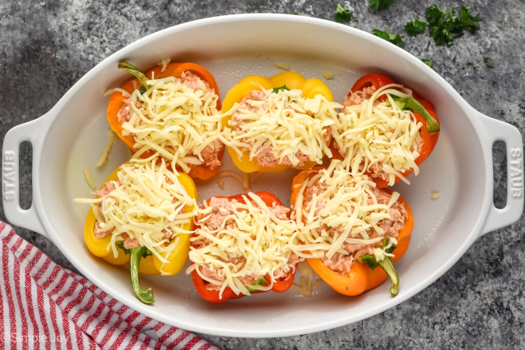 uncooked chicken stuffed peppers in a baking dish before baking - 7
