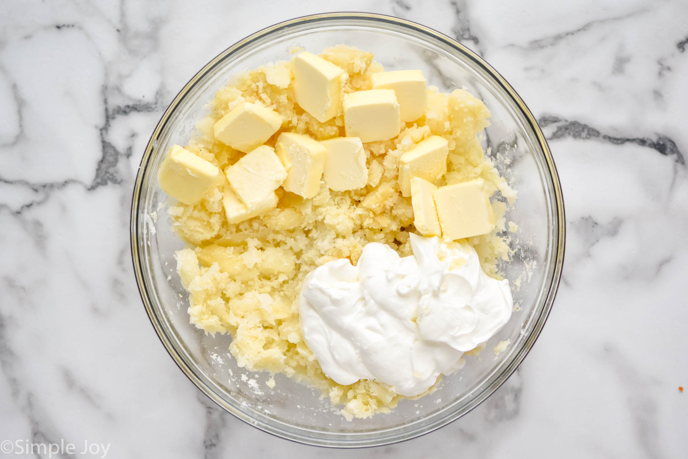 Overhead photo of a mixing bowl of ingredients for Twice Baked Potato Casserole recipe.