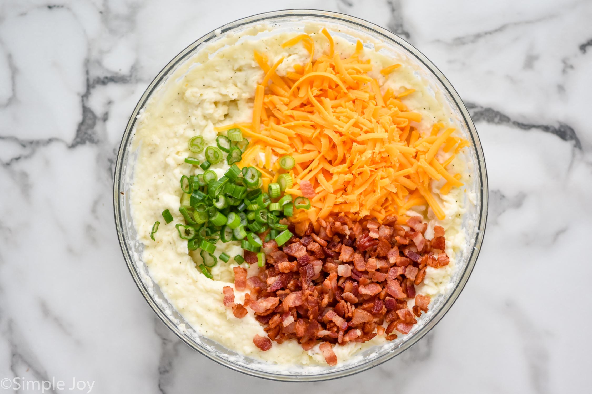 Overhead photo of a mixing bowl of ingredients for Twice Baked Potato Casserole
