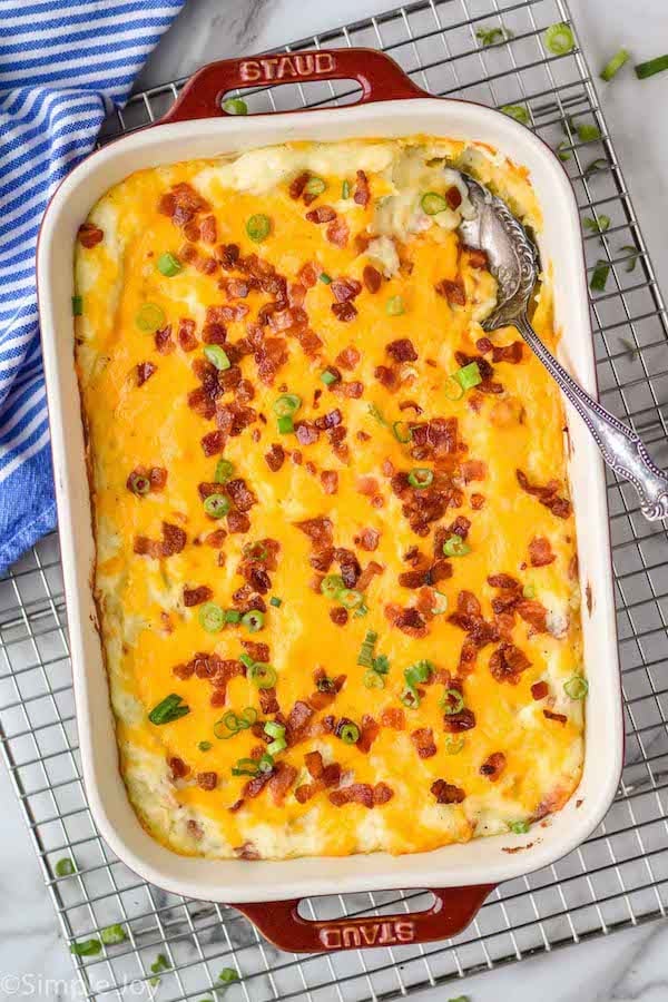 Overhead photo of a baking dish of Twice Baked Potato Casserole with a spoon for serving.