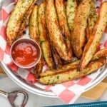 Pinterest graphic of Air Fryer Potato Wedges. Photo is overhead photo of Air Fryer Potato Wedges served with ketchup for dipping. Text says, "Air fryer potato wedges simplejoy.com."