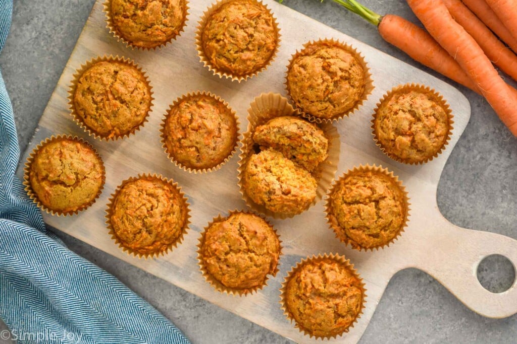 Overhead photo of Carrot Cake Muffins. One muffin is broken in half for eating.