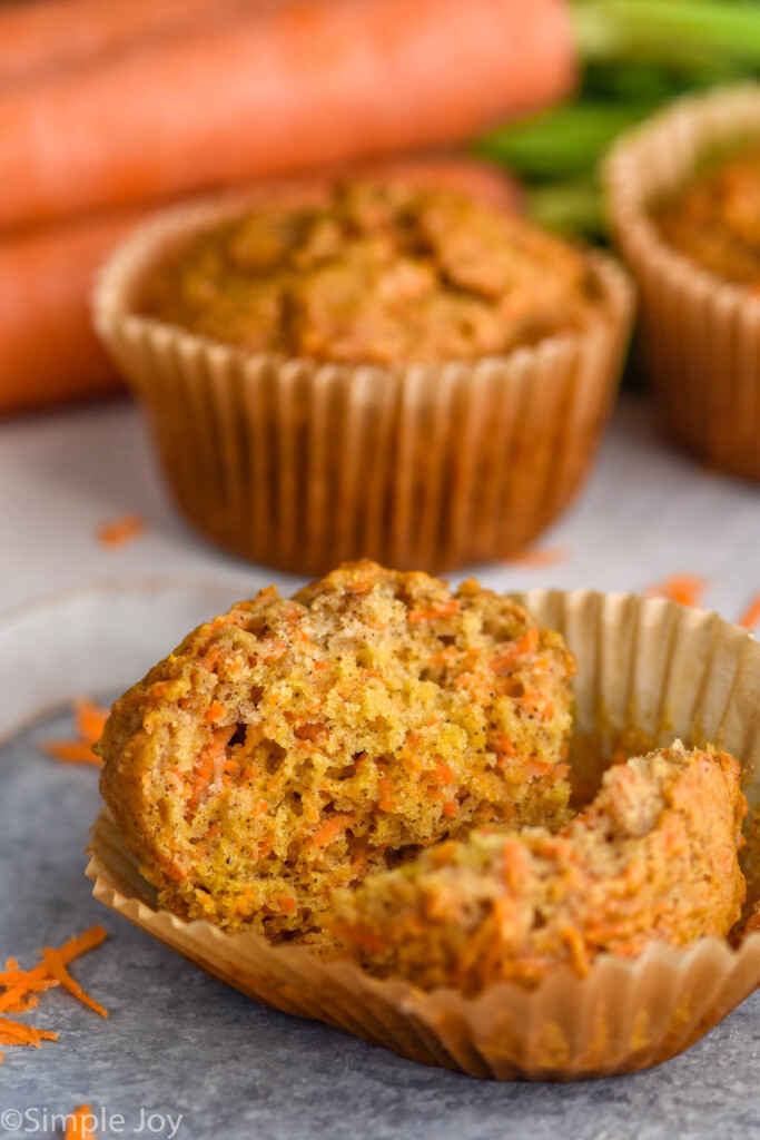 Overhead photo of Carrot Cake Muffins. Front muffin is broken in half for eating.