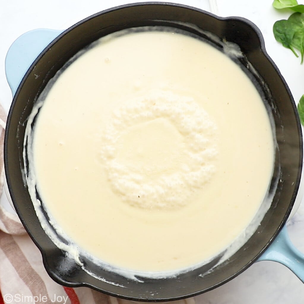 overhead of a cream sauce simmering in a pan