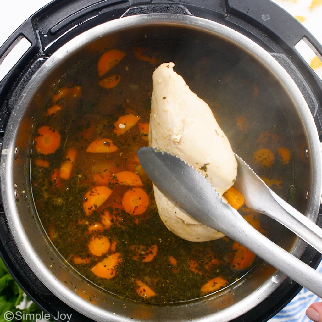 pulling a chicken breast out of an instant pot