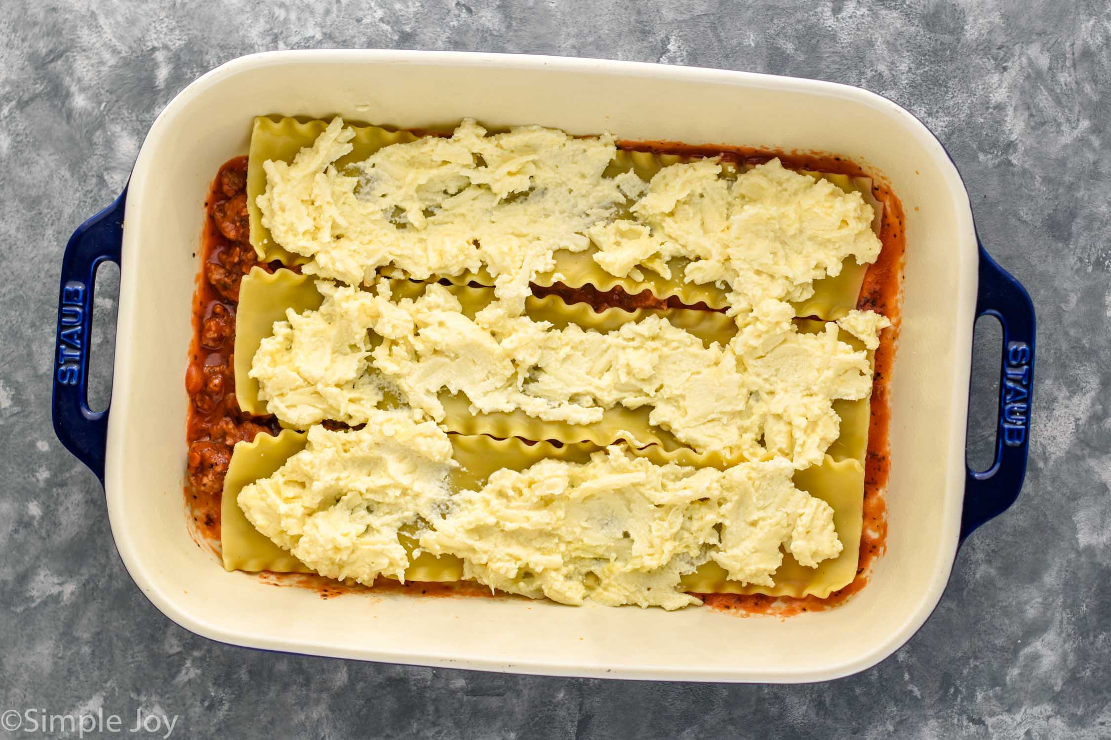 Overhead photo of a baking dish of ingredients for Homemade Lasagna recipe.