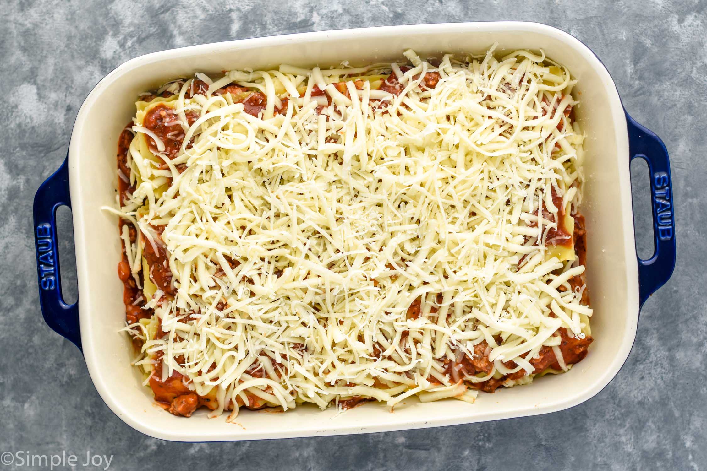 Overhead photo of a baking dish of ingredients for Homemade Lasagna before baking.