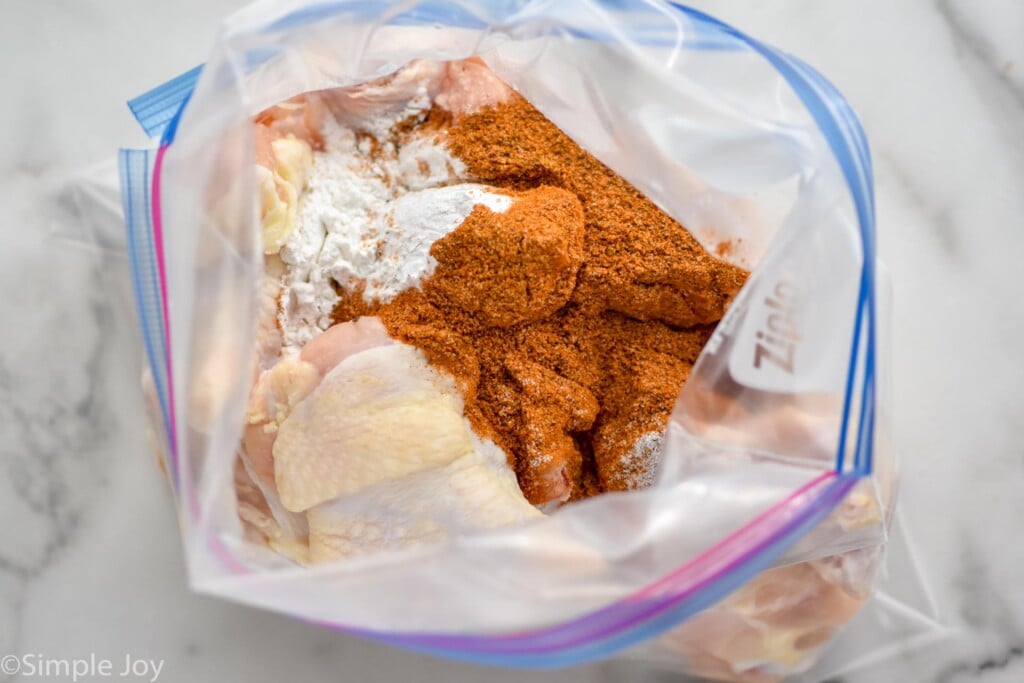 Overhead photo of chicken wings and seasoning in a bag for Old Bay Chicken Wings recipe.