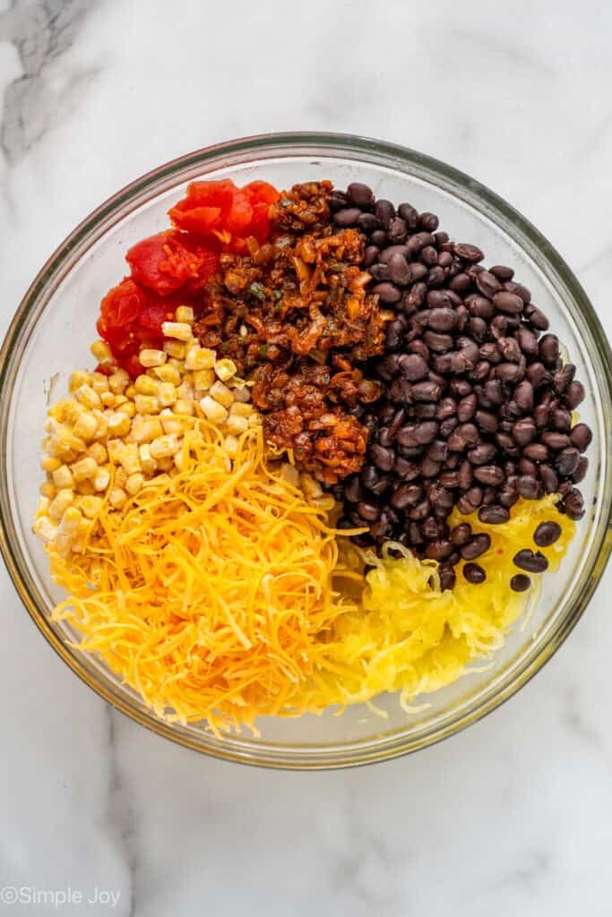 overhead of the filling for a spaghetti squash casserole - beans, squash, cheese, frozen corn, sauteed onion with spices, and fire roasted tomatoes, in a bowl