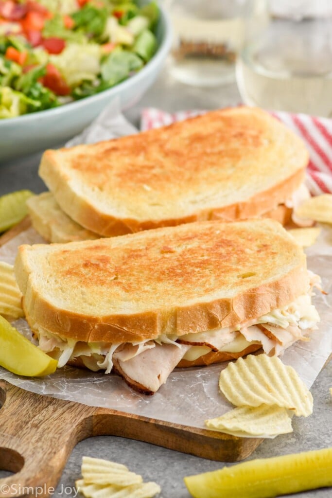 Overhead photo of two Rachel Sandwiches served with potato chips and pickle spears.