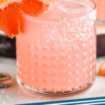 Pinterest graphic for Paloma recipe. Image is photo of Paloma garnished with a salted rim and a slice of grapefruit. Text says, "Paloma cocktail simplejoy.com"