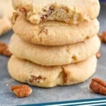 Pinterest graphic for Pecan Sandies recipe. Image is close up photo of a stack of Pecan Sandies with a bite taken out of the top cookie. Text says, "Pecan Sandies simplejoy.com."