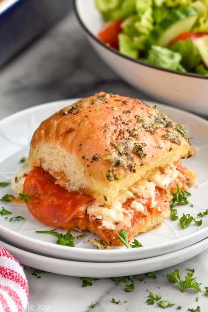 Overhead photo of Pizza Slider on a plate. Bowl of salad also on counter.