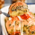 Close up photo of a Pizza Slider being served from baking dish of Pizza Sliders. - 11