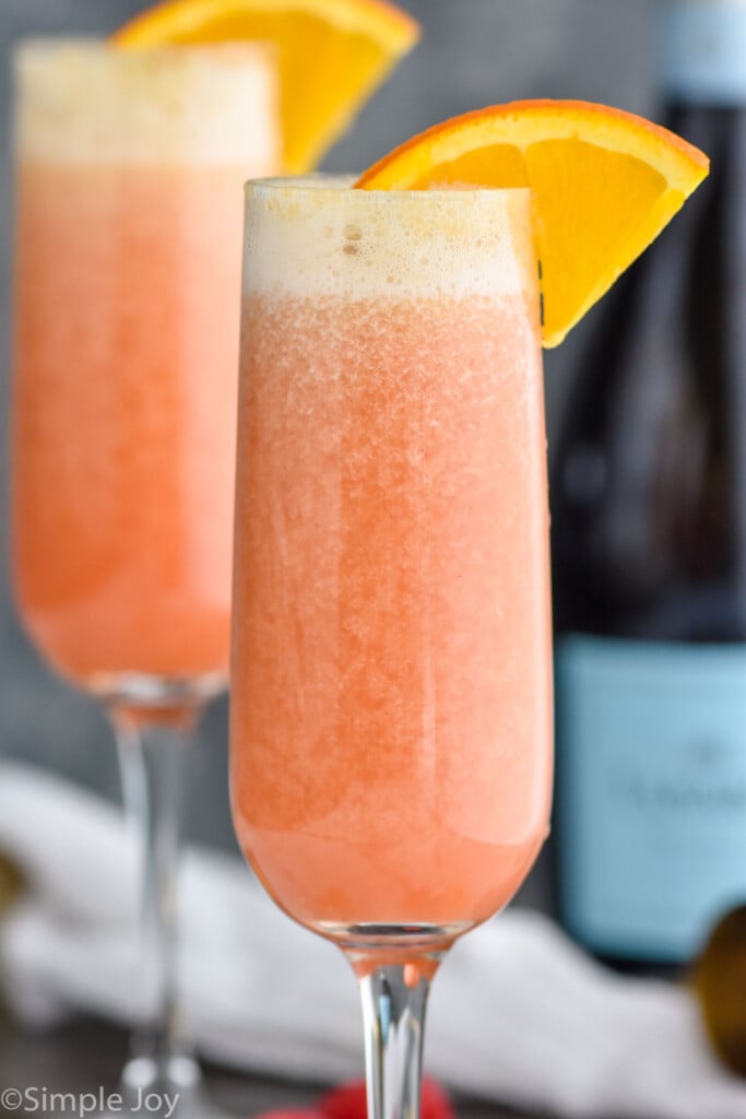 Close up photo of Raspberry Mimosa garnished with an orange slice.
