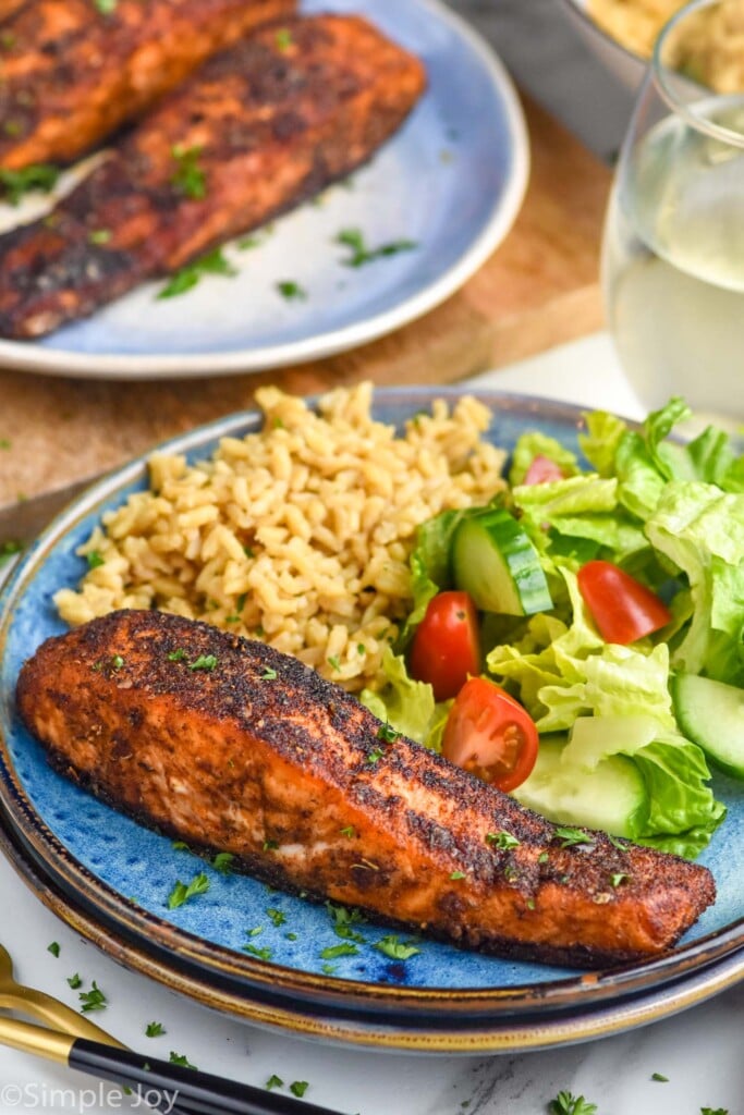 Overhead photo of Blackened Salmon served on a plate with salad and rice.