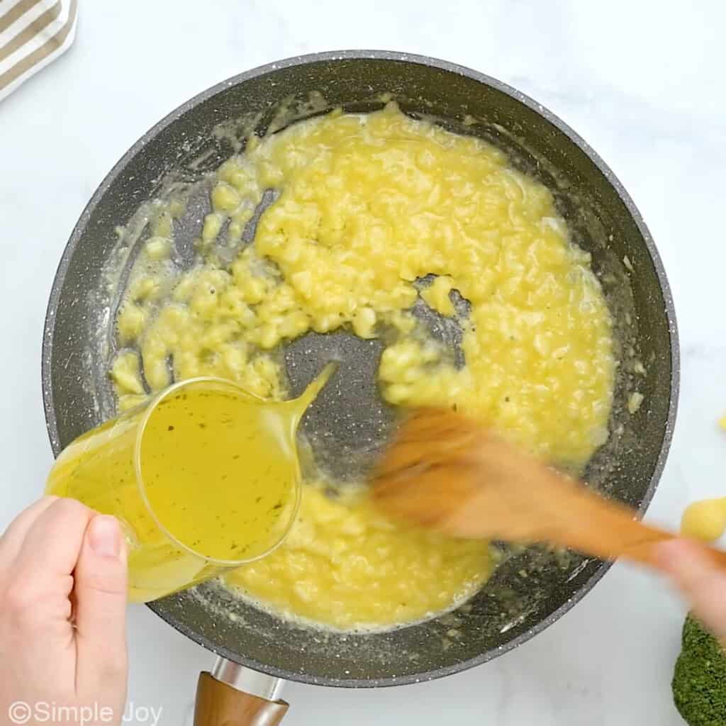 chicken stock being added to a skillet