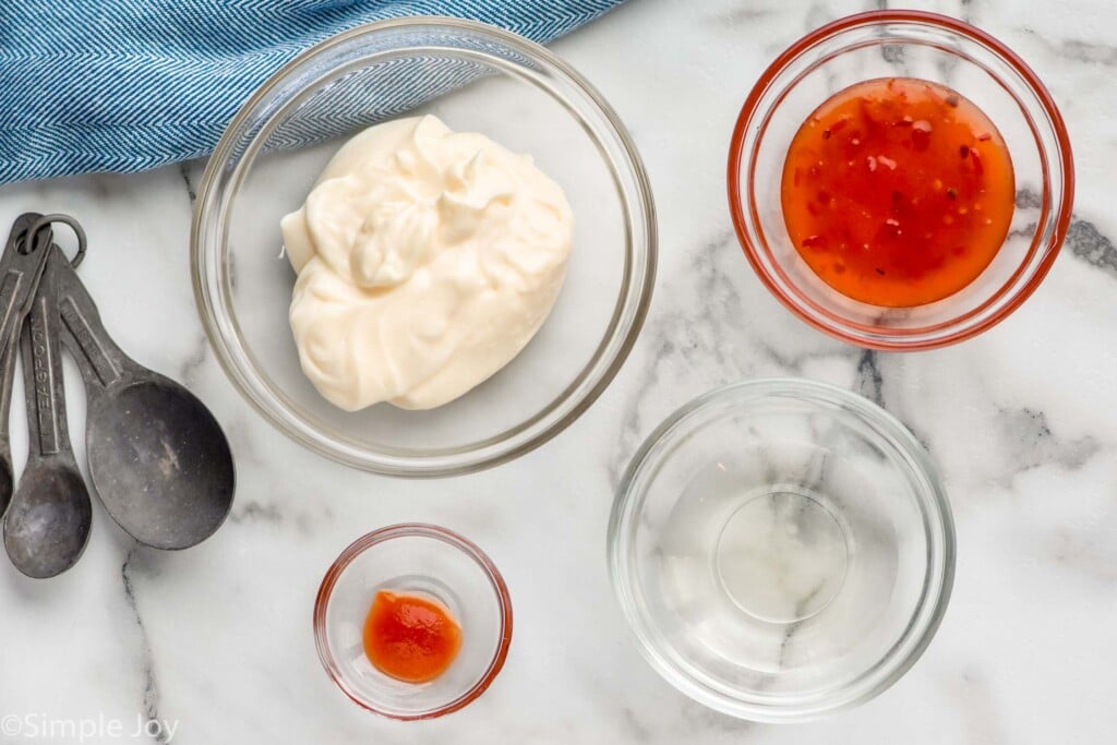 Overhead photo of bowls of ingredients for Bang Bang Sauce and measuring spoons.