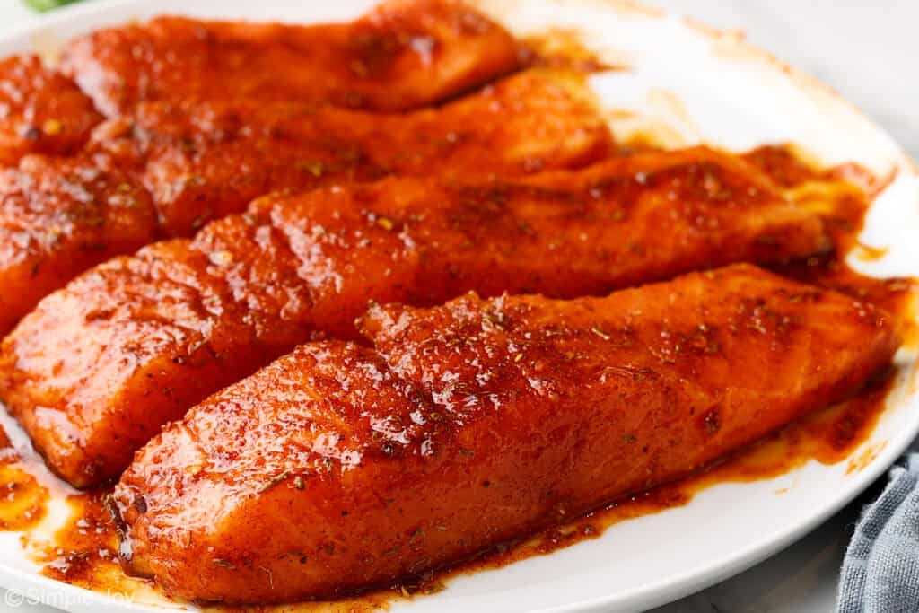 close up of cajun seasoning and oil smothered over four salmon filets