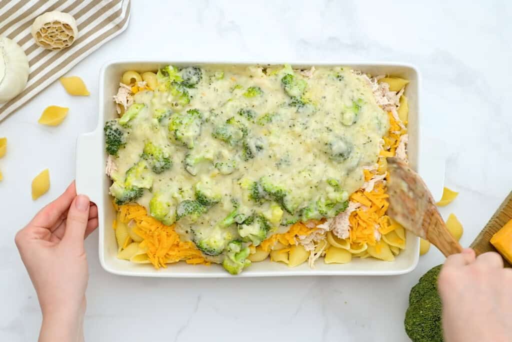 ingredients for chicken broccoli noodle casserole in a baking dish to be baked