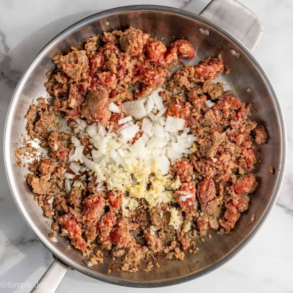 sausage, onion, and garlic cooking in a skillet
