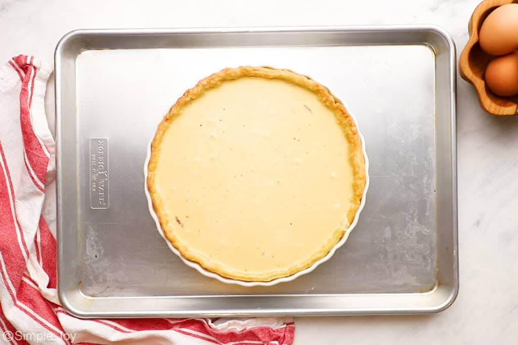 overhead of an unbaked quiche on a baking sheet