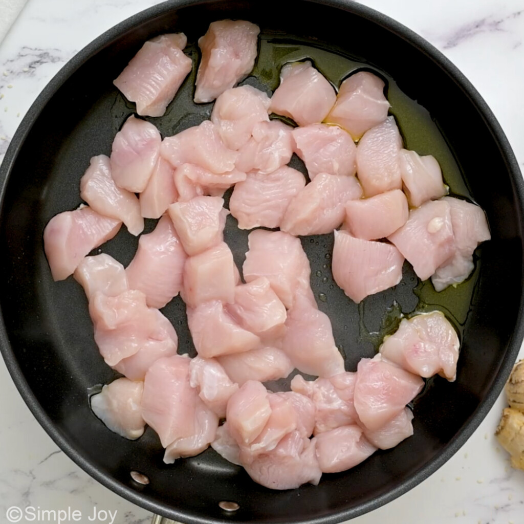overhead of raw chicken in a skillet