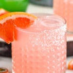 Close up photo of Paloma cocktail garnished with a grapefruit slice.