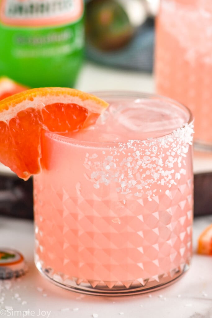 Close up photo of Paloma cocktail garnished with a grapefruit slice.