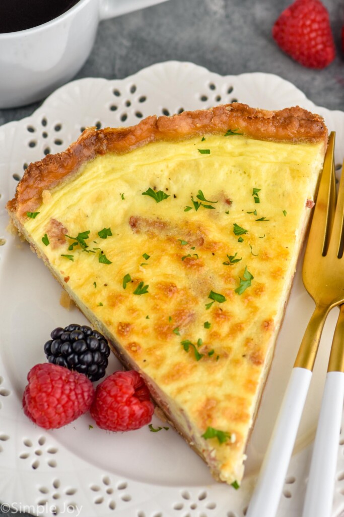 overhead of a piece of quiche Lorraine on a plate with some berries