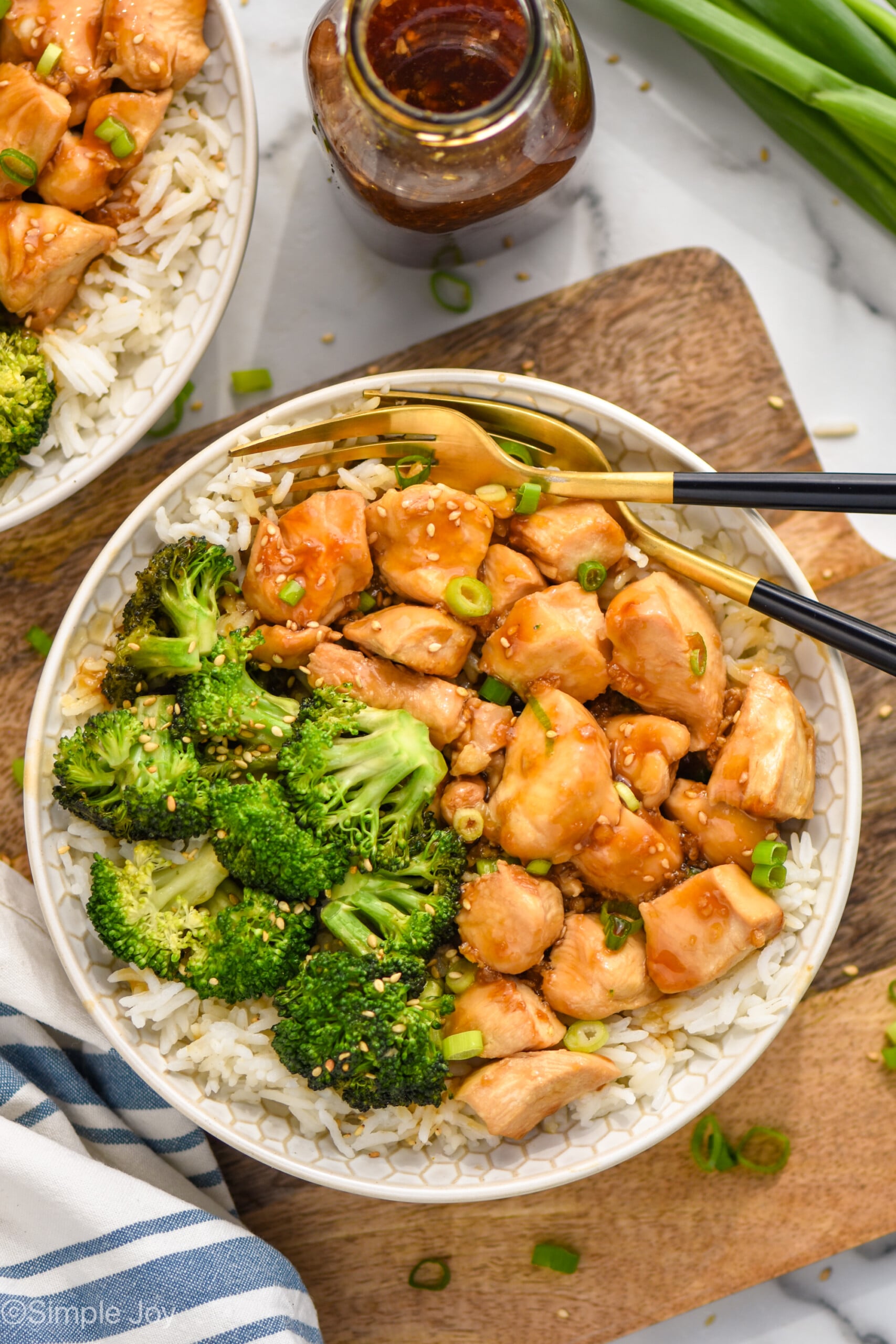 Overhead photo of teriyaki chicken bowl served with broccoli over rice and two forks