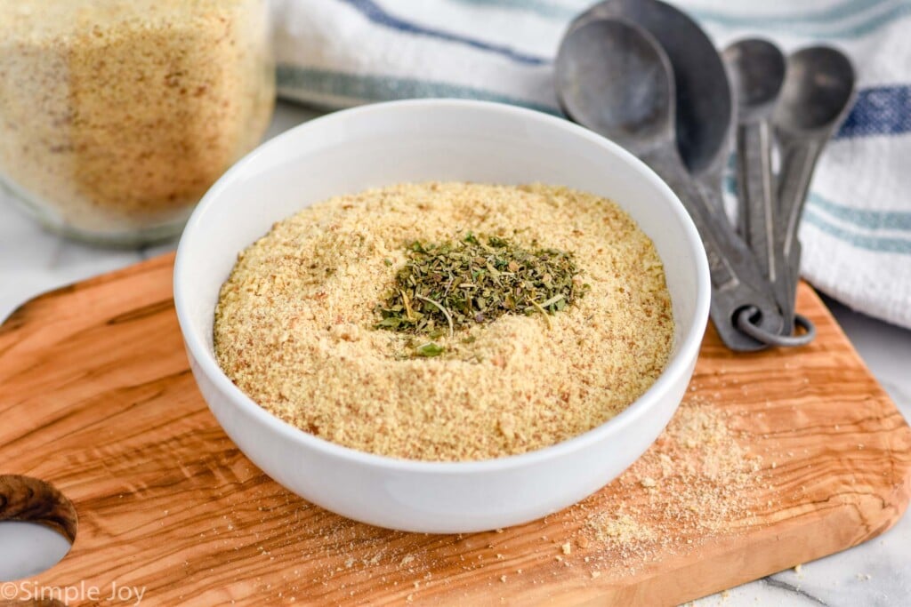 Overhead photo of a bowl of Breadcrumbs with seasoning. Measuring spoons sit on counter beside bowl of Breadcrumbs.