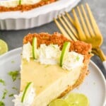 Pinterest graphic for Key Lime Pie recipe. Text says, "the best Key Lime Pie recipe simplejoy.com." Image is photo of a slice of Key Lime Pie served on a plate garnished with slices of lime. Forks on counter beside plate.