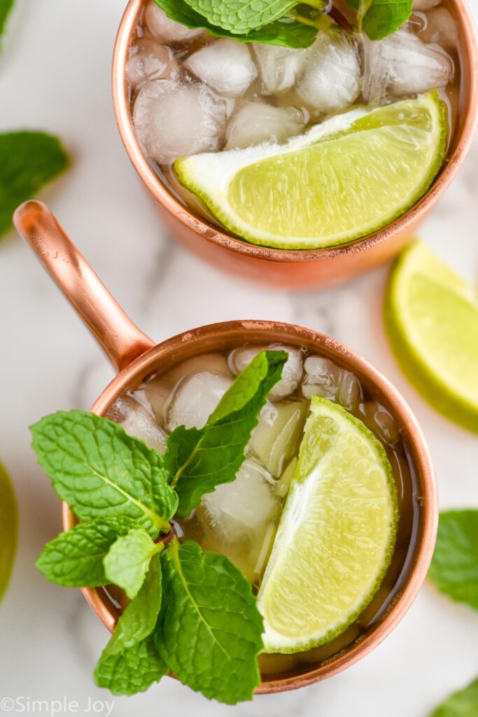 Overhead photo of Kentucky Mules served in copper mugs and garnished with mint leaves and slices of lime.