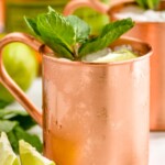 Photo of Kentucky Mules served in copper mugs and garnished with lime slices and mint leaves.